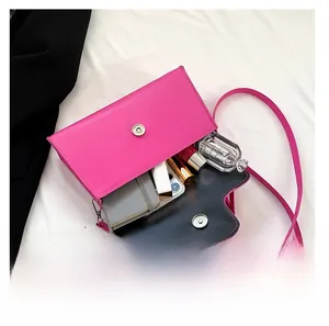 Interior capacity of magenta square crossbody bag holding phone, wallet and perfume