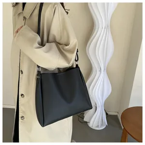 Détail d'un sac fourre-tout noir minimaliste avec bandoulière et finition mate