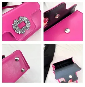 Detail view of rhinestone buckle, magnetic closure and protective metal feet on rose red bag