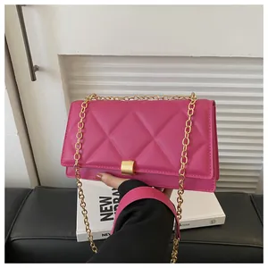Detail of hot pink quilted crossbody bag with gold chain strap and elegant metal lock