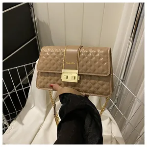 Detailed close-up of quilted khaki chain bag showing golden metal buckle and fashion logo