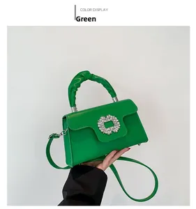 Detail of green satchel bag with crystal buckle and unique pleated handle texture