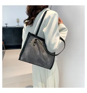 Close-up of vintage grey suede tote bag with golden hardware and black strap detail
