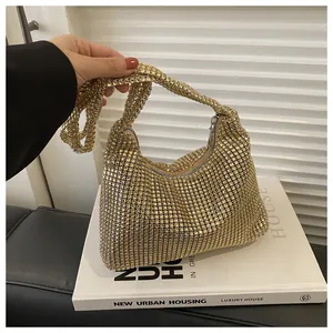 Detail der glitzernden Gold-Rhinestone-Netzoberfläche und des Griffs der Abendtasche