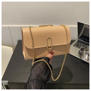 Detail of beige faux leather square bag with gold metal chain and oval clasp closure