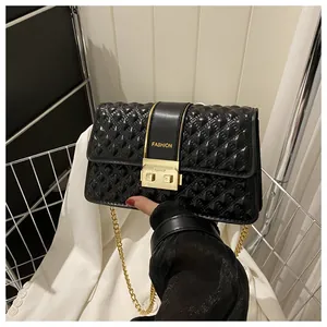 Close-up of black quilted chain bag with gold hardware and fashion lettering detail