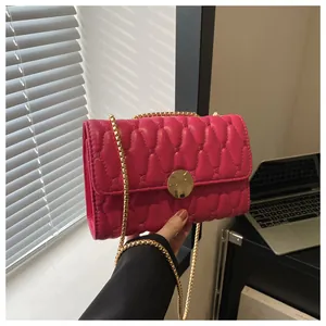Detailaufnahme der fuchsiafarbenen gesteppten Tasche mit goldener Kette und Schnalle