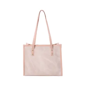 Pink canvas and leather tote bag with gold rivets shown from a professional front view