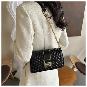 Detail of black quilted crossbody bag with gold chain strap and FASHION logo