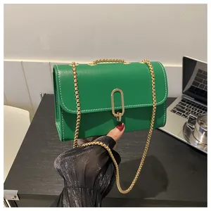 Close-up of bright green crossbody bag with white contrast stitching and gold chain