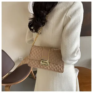 Detail view of quilted khaki crossbody bag with gold chain strap and metal buckle