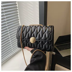 Detailaufnahme der schwarzen Stepptasche mit goldener Metallschließe und Kettenriemen