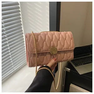 Detailansicht der hellrosa gesteppten Tasche mit goldener Rundschnalle und Kettengurt