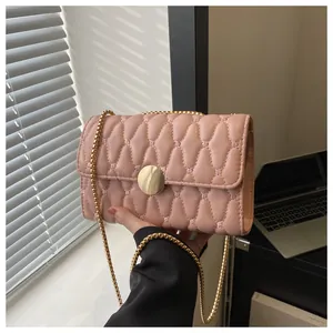 Detail der rosa gesteppten Handtasche mit Wellentextur, Goldverschluss und Kugelkettenriemen