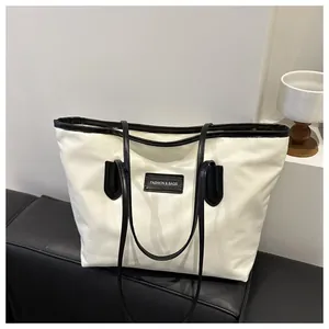 Detail view of large Oxford cloth tote bag with black trim and FASHION & BAGS logo