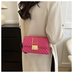 Close-up of a pink quilted crossbody bag with gold fashion clasp and chain strap