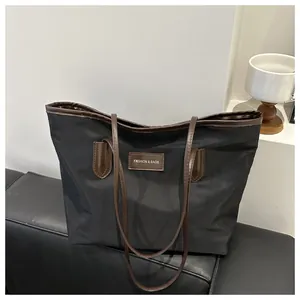 Detail view of Oxford cloth tote bag showing dual-tone design and premium leather tag