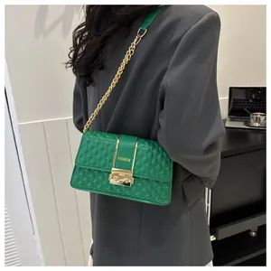 Close-up of green quilted shoulder bag with gold metal bars and FASHION logo detail