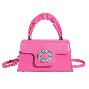 Vibrant pink mini crossbody bag with scrunchie handle and sparkling diamond buckle
