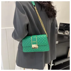 Detailed shot of emerald green quilted crossbody bag with gold metal chain and fashion buckle