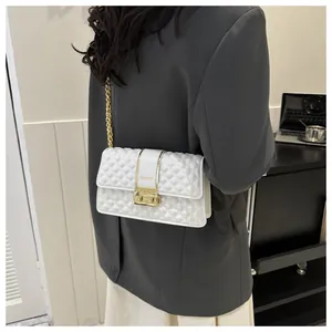 Close-up of white quilted crossbody bag with gold chain strap and FASHION metal buckle
