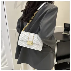 Detail of white quilted crossbody bag with gold chain strap and FASHION lettering