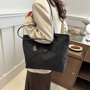Large black Oxford tote bag for women showing a sleek waterproof design for daily commute