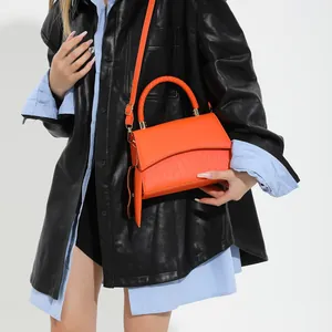 Bolso bandolera naranja con solapa de cocodrilo y asa tejida para mujer