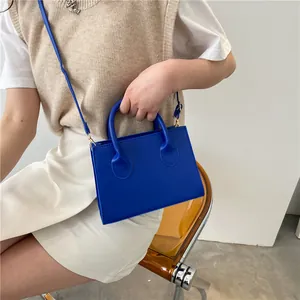 Minimalist royal blue square crossbody bag with top handles and adjustable strap