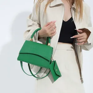 Bolso bandolera verde con patrón de cocodrilo, asa trenzada y pequeño monedero