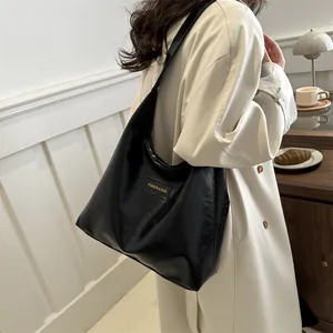 Bolso tote negro minimalista de gran capacidad en cuero PU mostrado por modelo en interior
