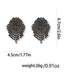 Dettaglio orecchini con cristalli verdi e nappe con dimensioni di 6,7 cm x 4,5 cm