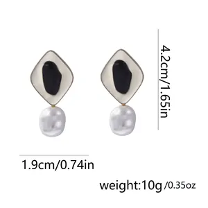 Detalle de pendientes geométricos de aleación con perlas y medidas de 4,2 cm por 1,9 cm