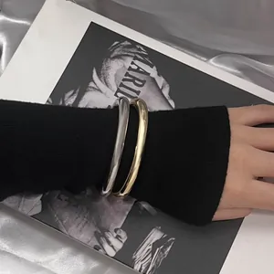 Μινιμαλιστικό σετ βραχιόλια CCB σε χρυσό και ασημί φορεμένα πάνω από περιοδικό μόδας