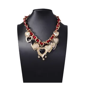 Barockkette mit goldenem Glied, rotem Seidenband und mehreren Herzanhängern am Display