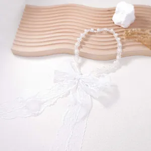 Close-up of elegant white pearl beads and delicate lace bow on a floral necklace