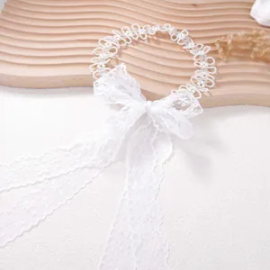 Close-up of white lace necklace with pearls, transparent beads and long ribbon bow