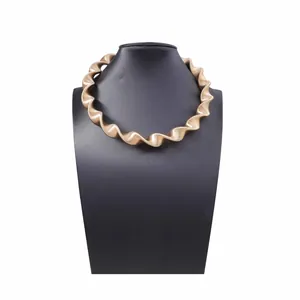 Collana girocollo a spirale dorata stile punk con trama a righe su manichino nero
