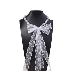 Detail of white lace choker necklace with pearl beads and elegant bow hanging on a neck model