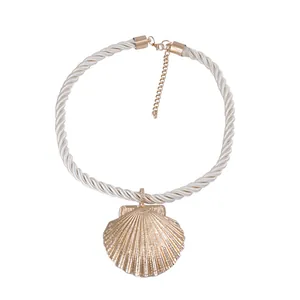 Macro shot of gold shell pendant with woven rope strap and adjustable metal clasp detail