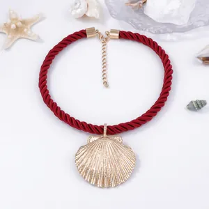 Golden shell pendant necklace with bold red woven rope, minimalist ocean style jewelry