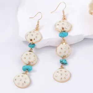 Boucles d'oreilles bohèmes avec pendentifs étoiles blanches et détails en turquoise