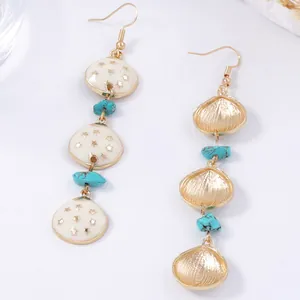 Boucles d'oreilles bohèmes avec étoiles en émail blanc et pierres turquoise sur fond blanc