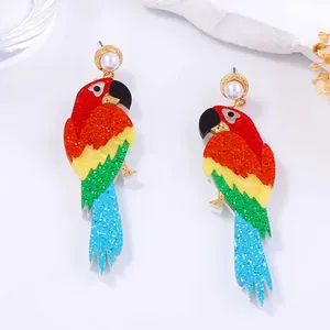 Détail des boucles d'oreilles perroquet avec paillettes colorées et perles blanches