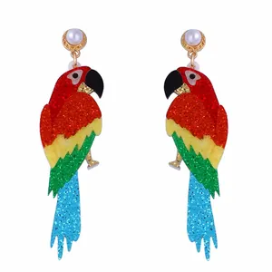 Détail des boucles d'oreilles perroquet colorées à paillettes avec perles blanches