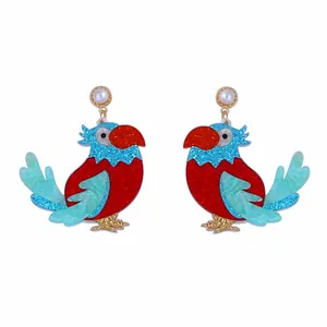 Vue détaillée des boucles d'oreilles perroquet avec paillettes rouges et bleues et perle