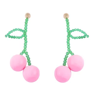 Detailed view of handmade beaded cherry earrings with pink resin fruit and green leaves