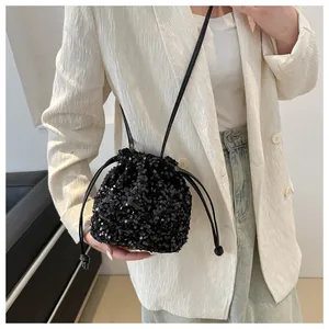 Detailed view of the black sequin drawstring bucket bag with shiny metallic texture