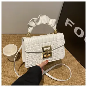 Detail of white crocodile pattern PU leather handbag with gold square buckle and ruched handle