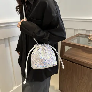 White sequin drawstring bucket bag with elegant chain strap for evening party attire